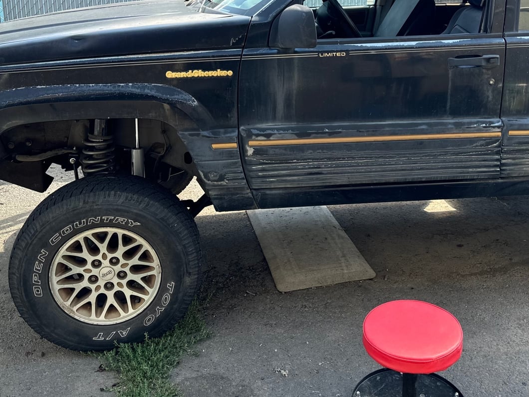 Jeep Grand Cherokee ZJ with a front leveling kit installed, showing increased front ride height and suspension clearance.