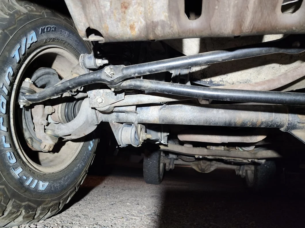 Front suspension and steering linkage of a Jeep Grand Cherokee ZJ, showing the tie rod, drag link, and sway bar.