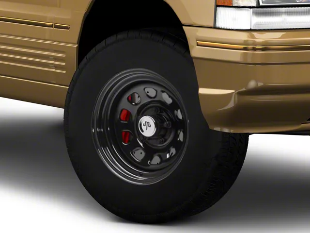 Close-up of a black steel wheel with a 28x9-inch tire mounted on the front of a 1993&ndash;1998 Jeep Grand Cherokee ZJ