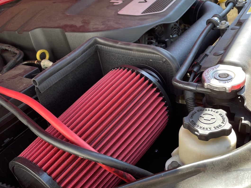 Jeep V6 engine bay with an enclosed cold air intake system and reusable high-flow air filter.