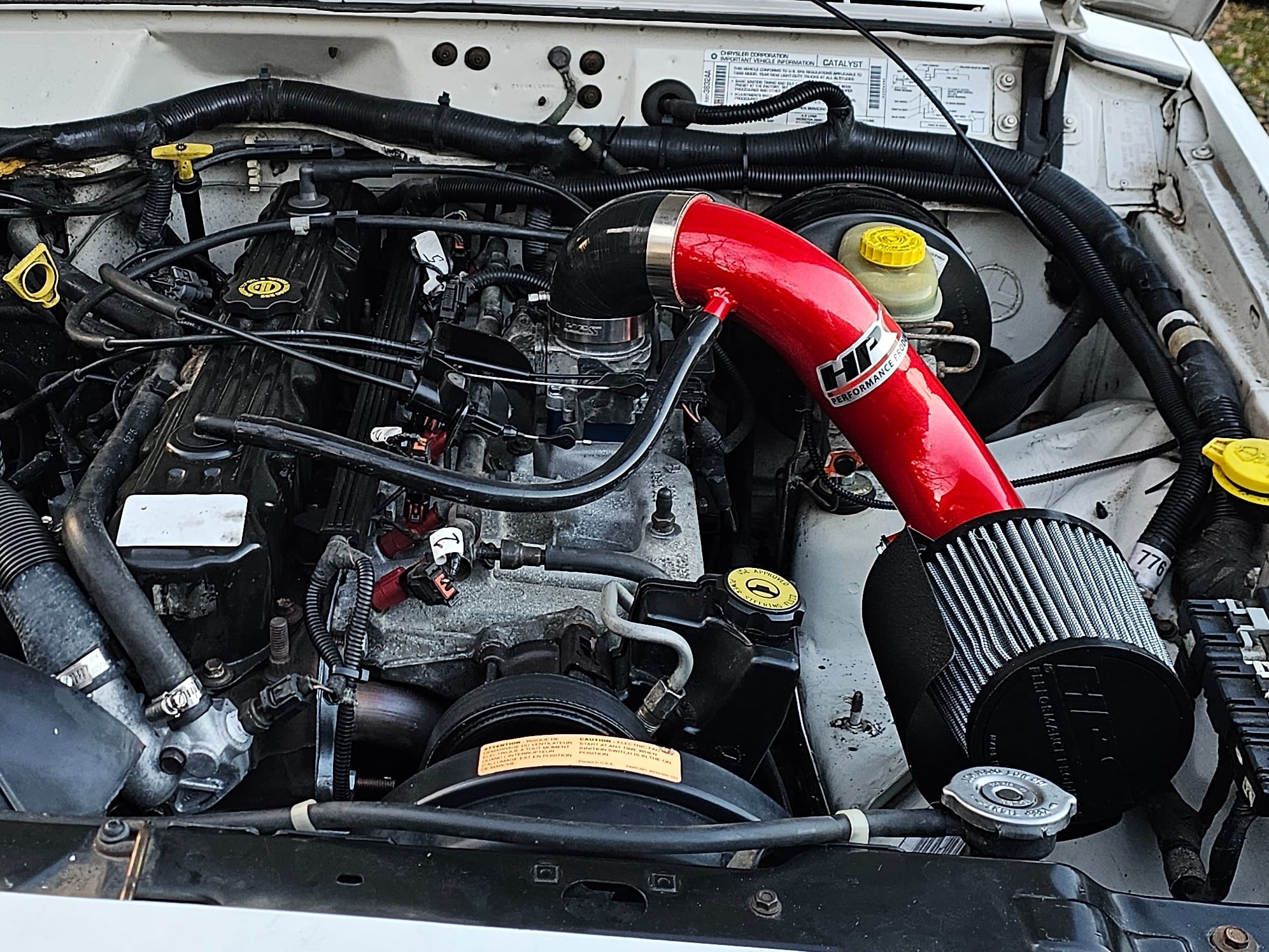 Jeep 4.0L inline-six engine bay with an aftermarket HD Performance cold air intake installed.