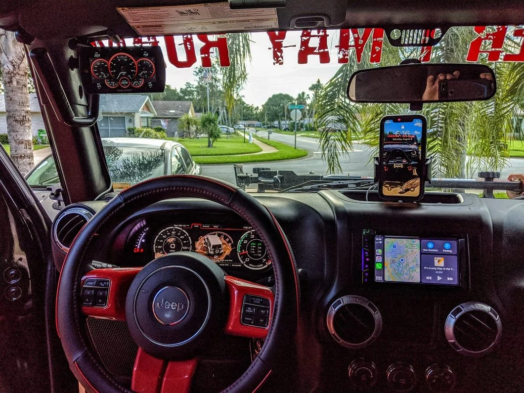 Custom Jeep interior with a digital instrument cluster, touchscreen infotainment system, and smartphone mount.
